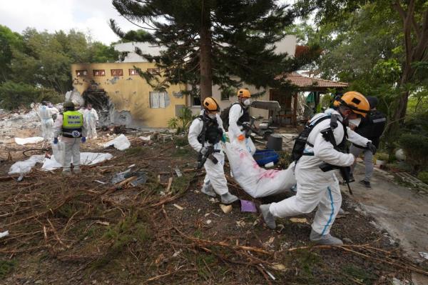 Israeli soldiers carry the body of a Hamas militant in Kibbutz Be'eri on Wednesday.