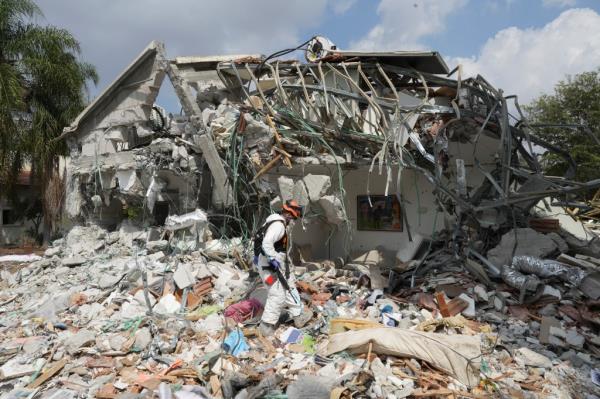 An Israeli soldier walks by a house destroyed by Hamas militants in Kibbutz Be'eri.